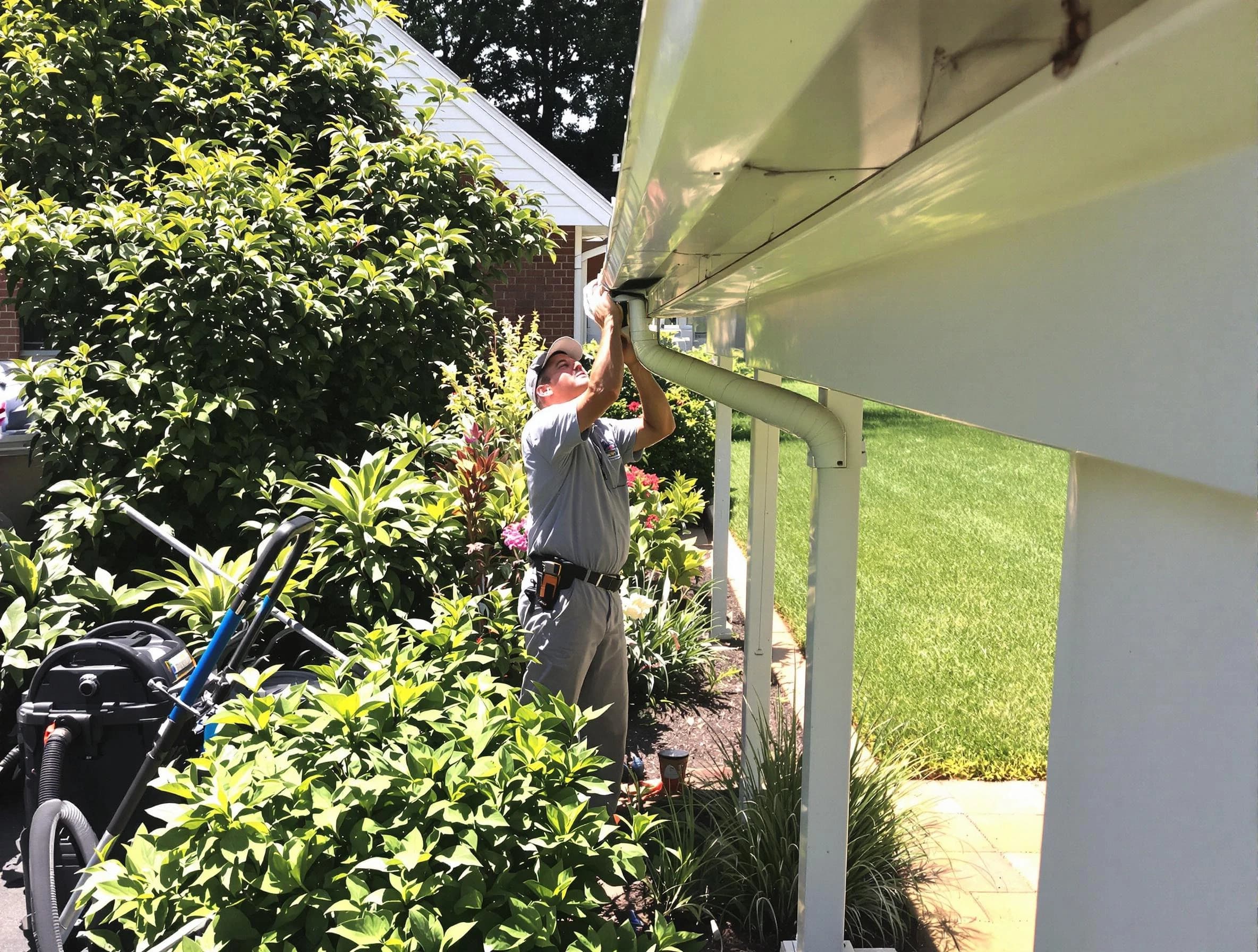 Technician flushing a blockage from a downspout in East Cleveland, OH